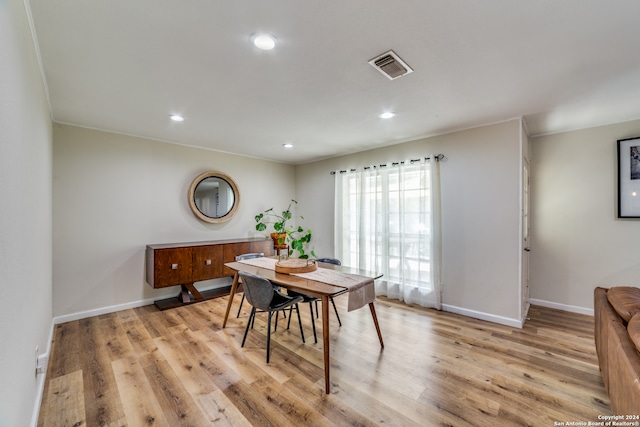 dining space featuring light hardwood / wood-style flooring and ornamental molding