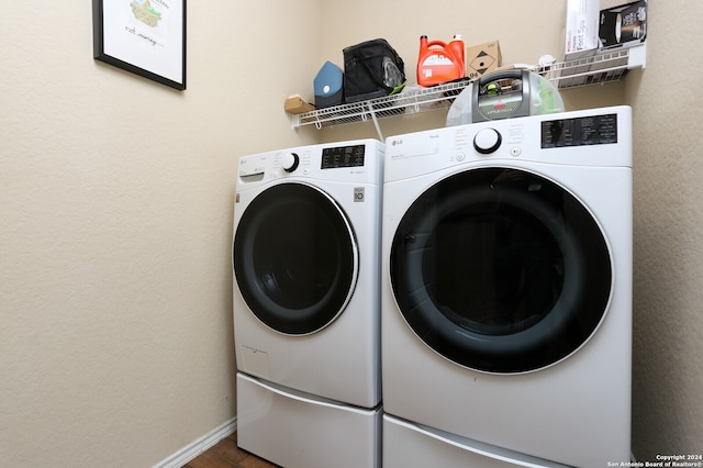 clothes washing area featuring hardwood / wood-style floors and washer and clothes dryer