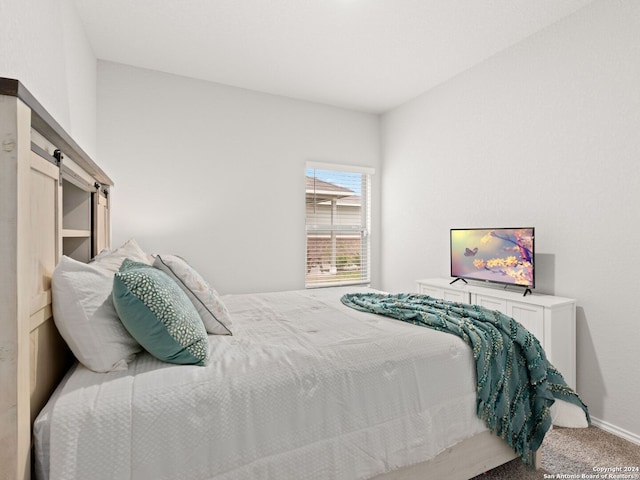 bedroom with carpet floors and a barn door