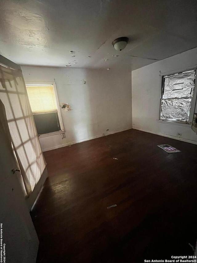 unfurnished room with dark wood-type flooring