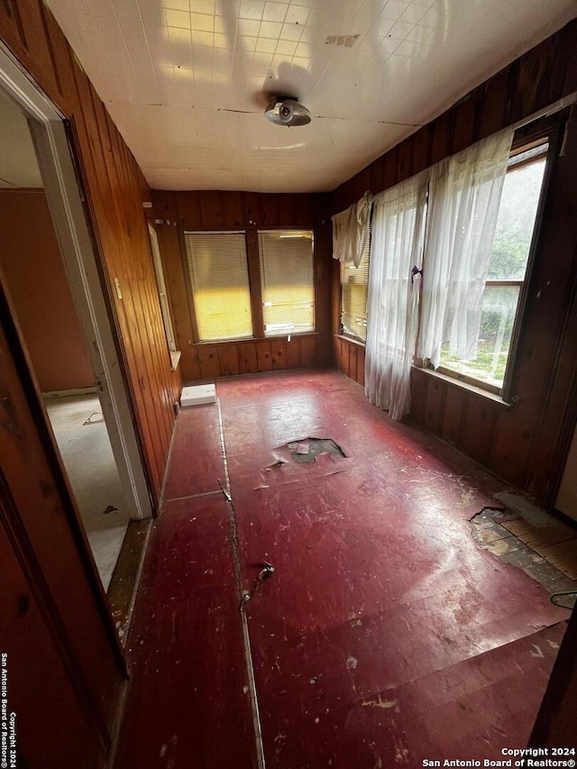 miscellaneous room with wood walls and ceiling fan