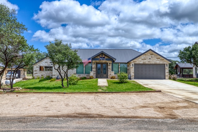 view of front of home featuring french doors, a garage, and a front yard