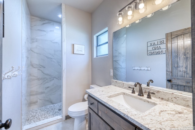 bathroom featuring vanity, toilet, and tiled shower