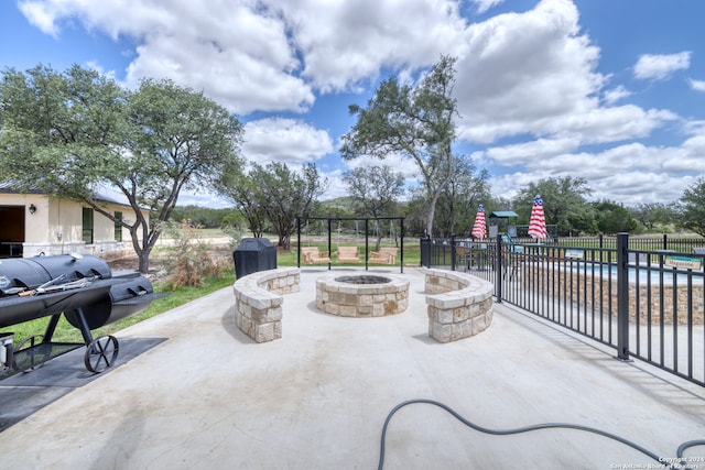 view of patio / terrace with a fenced in pool and an outdoor fire pit