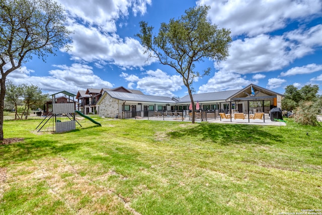 view of yard featuring a playground and a patio