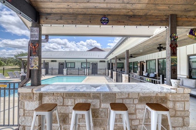 view of swimming pool with an outdoor bar and ceiling fan