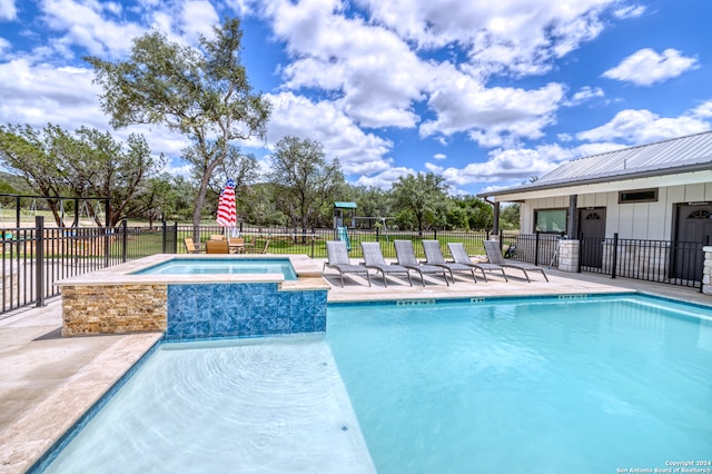 view of swimming pool featuring a patio area and an in ground hot tub