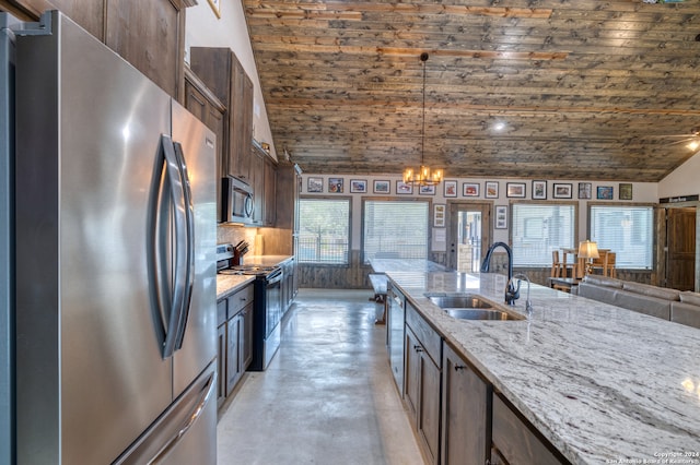 kitchen featuring pendant lighting, stainless steel appliances, sink, and light stone counters