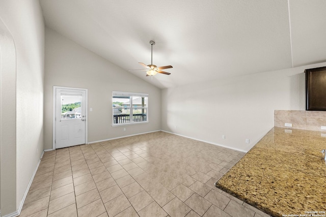 unfurnished living room with ceiling fan, light tile patterned floors, and high vaulted ceiling