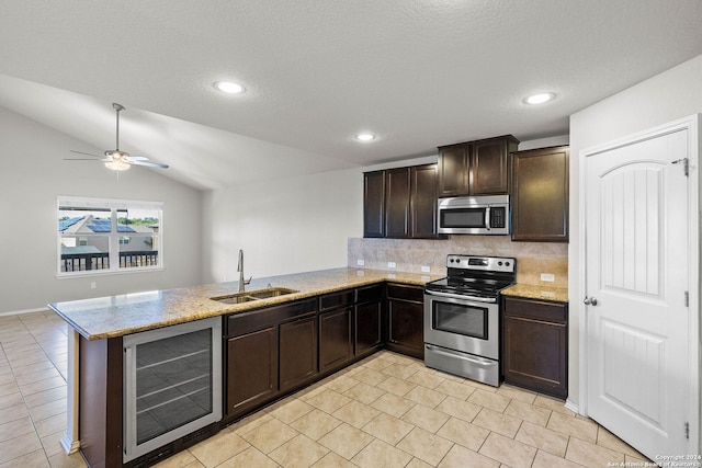 kitchen featuring vaulted ceiling, kitchen peninsula, sink, appliances with stainless steel finishes, and wine cooler