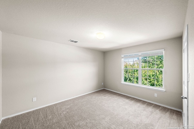 empty room with a textured ceiling and carpet flooring