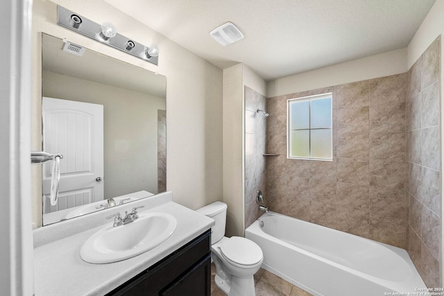 full bathroom with tile patterned flooring, tiled shower / bath, toilet, and vanity