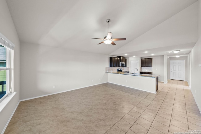 unfurnished living room with high vaulted ceiling, sink, light tile patterned floors, and ceiling fan