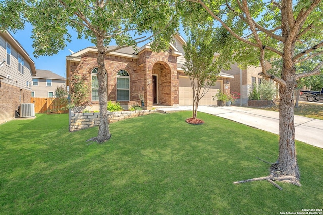 view of front of property with central AC unit, a front yard, and a garage