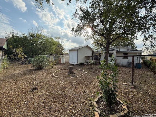 view of yard with central AC unit and a storage unit