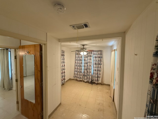 corridor featuring wood walls