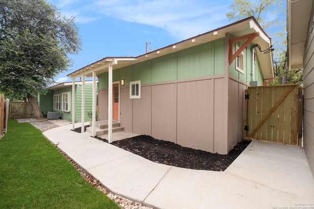 view of side of home with a lawn and central AC