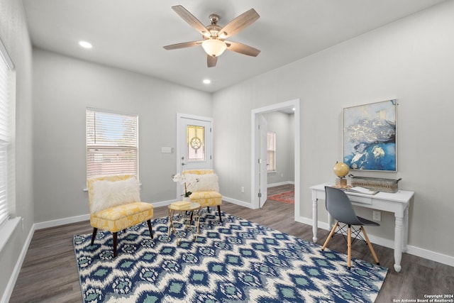 living area with dark wood-type flooring and ceiling fan