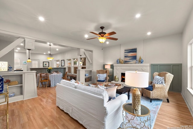 living room with light hardwood / wood-style flooring and ceiling fan