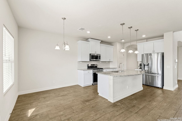 kitchen featuring stainless steel appliances, white cabinetry, sink, an island with sink, and wood-type flooring