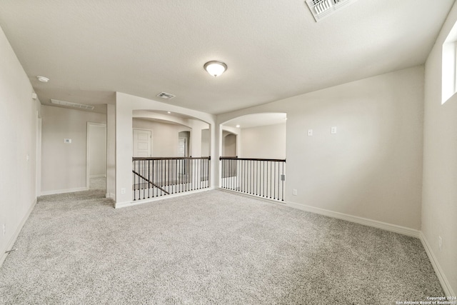 spare room with a textured ceiling and carpet