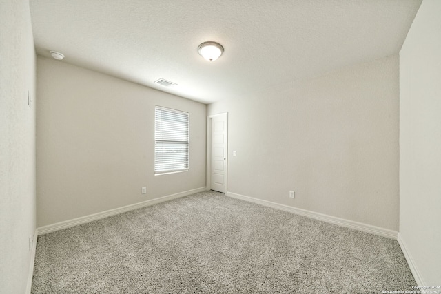 carpeted spare room with a textured ceiling