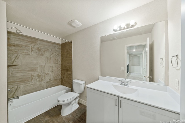 full bathroom with hardwood / wood-style flooring, a textured ceiling, vanity, toilet, and tiled shower / bath combo