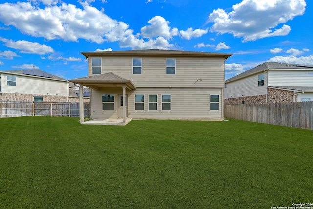 back of house with a lawn and a patio