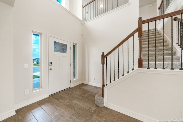 entrance foyer featuring a towering ceiling and hardwood / wood-style flooring