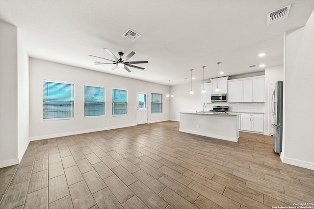 unfurnished living room featuring light hardwood / wood-style floors, ceiling fan, and sink