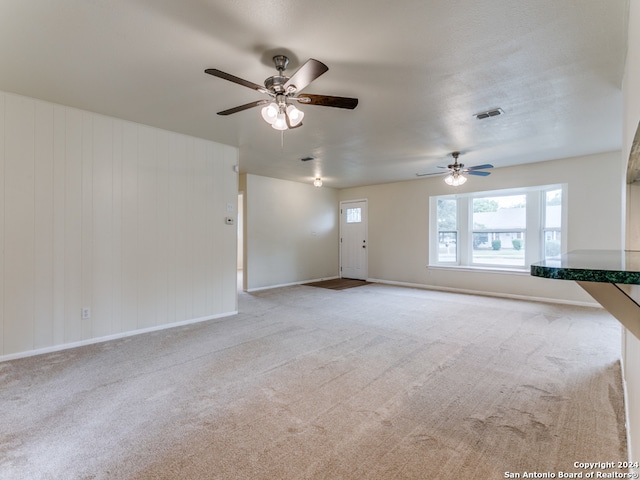 unfurnished living room with light carpet and ceiling fan