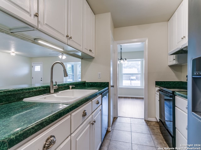 kitchen featuring white cabinetry, sink, light tile patterned floors, stainless steel dishwasher, and electric range