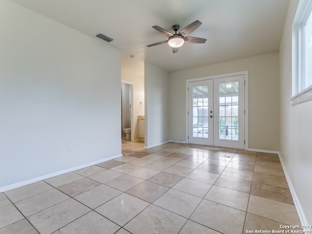 empty room featuring ceiling fan, light tile patterned floors, and french doors