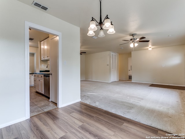 unfurnished room with light wood-type flooring, sink, and ceiling fan with notable chandelier