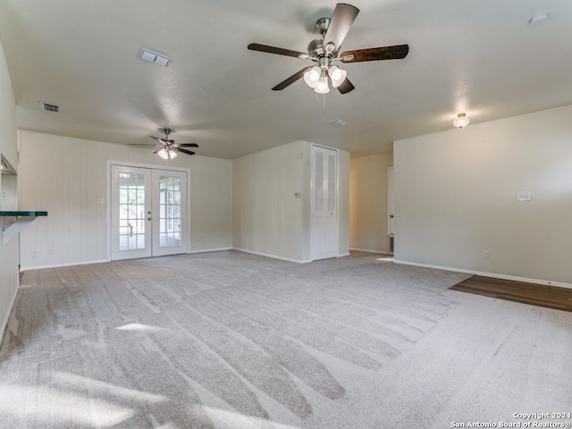 unfurnished living room with ceiling fan, french doors, and light colored carpet