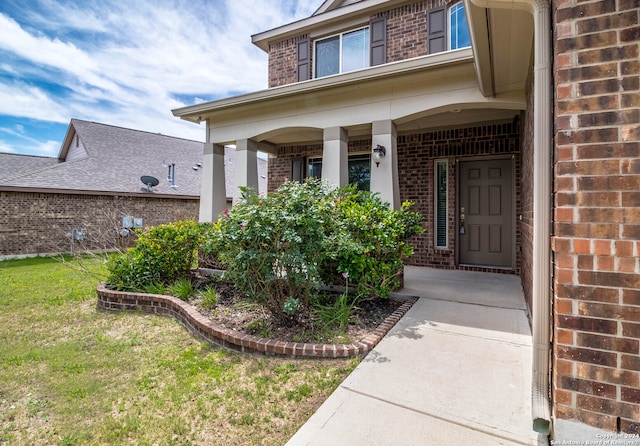 property entrance with a lawn and covered porch