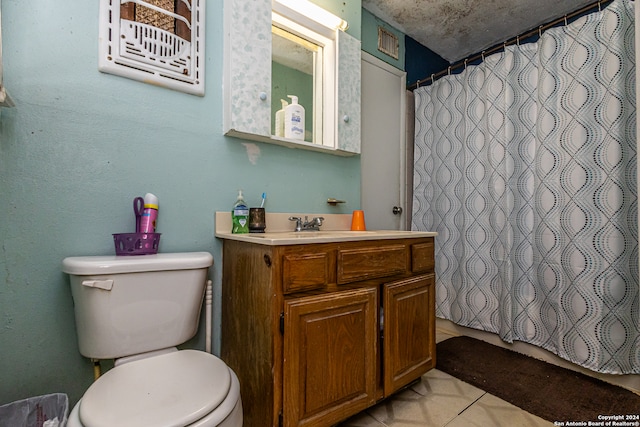 bathroom with toilet, vanity, and tile patterned flooring