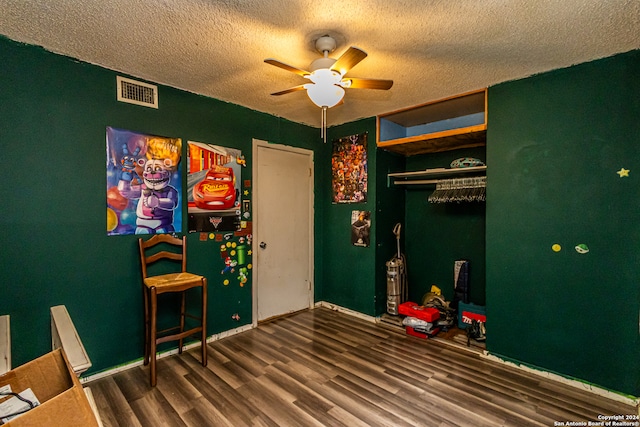 rec room featuring hardwood / wood-style floors, a textured ceiling, and ceiling fan