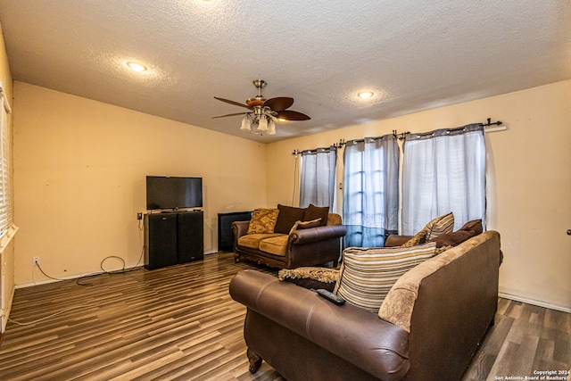 living room featuring ceiling fan, a textured ceiling, and dark hardwood / wood-style flooring