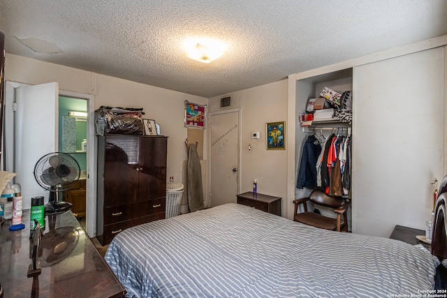 bedroom featuring a textured ceiling and a closet