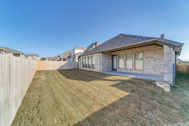 rear view of house featuring a yard and a patio area