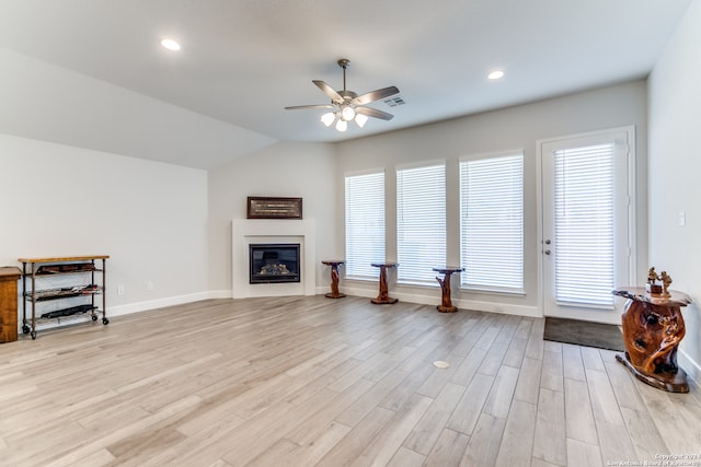 living room with light hardwood / wood-style floors, ceiling fan, and lofted ceiling