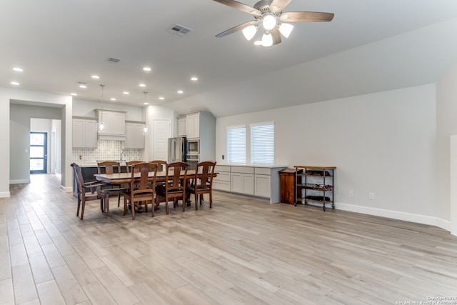 dining area featuring light hardwood / wood-style flooring, lofted ceiling, and ceiling fan