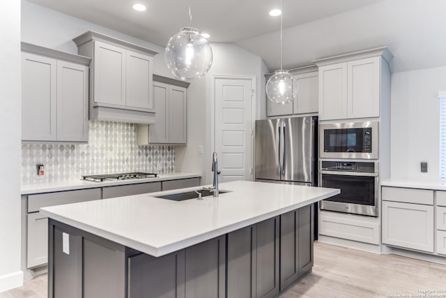 216 Paint Crk, Boerne, TX 78006 - kitchen featuring stainless steel appliances, a sink, a kitchen island with sink, backsplash, and light wood finished floors