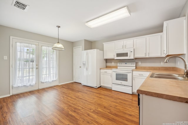 kitchen with sink, light wood-type flooring, white appliances, white cabinets, and pendant lighting