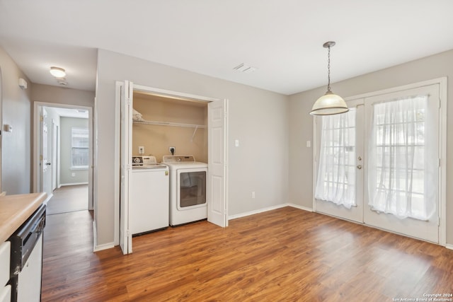 kitchen featuring french doors, decorative light fixtures, hardwood / wood-style floors, dishwasher, and washing machine and dryer