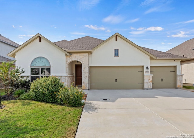 view of front of property featuring a garage and a front lawn