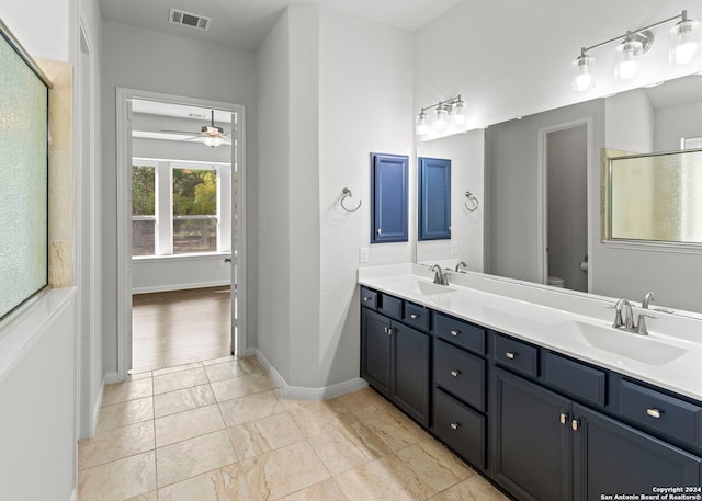 bathroom with vanity, ceiling fan, toilet, and a shower with door