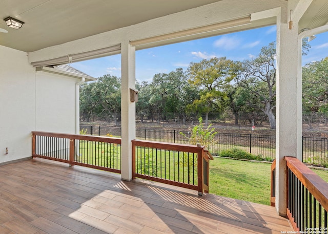 wooden terrace featuring a lawn