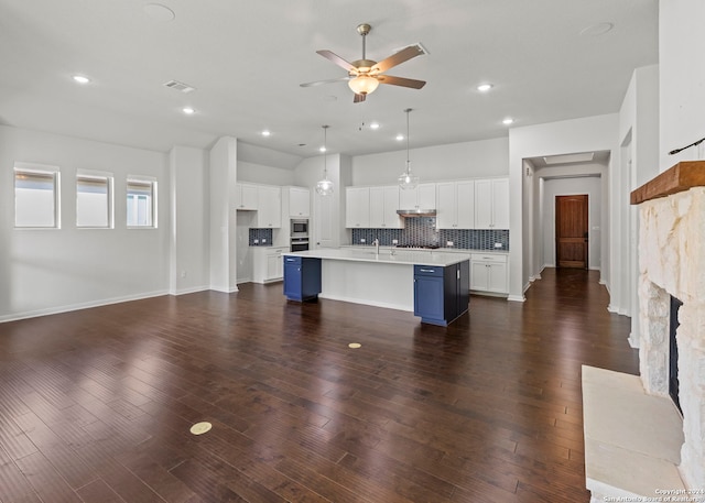 living room featuring dark hardwood / wood-style flooring, sink, ceiling fan, and a fireplace